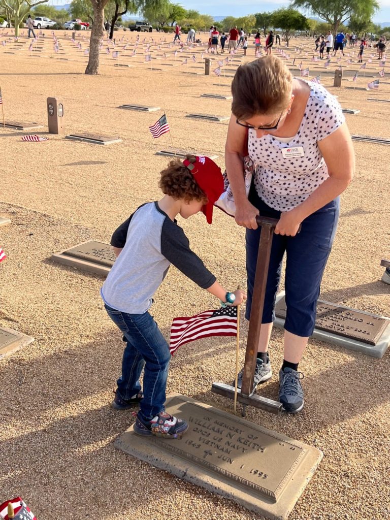 Placing flags at gravesites and attending Memorial Day services at the National Memorial Cemetery of Arizona.
